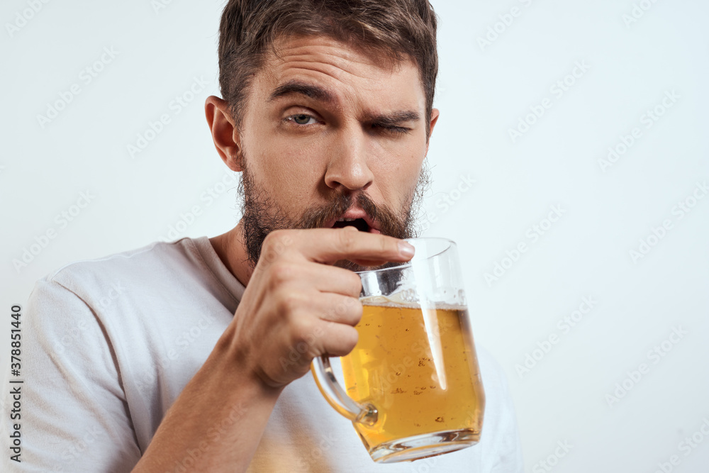 man with a mug of beer in his hands and a white t-shirt light background mustache beard emotions model man with a mug of beer in his hands and a white t-shirt light background mustache beard emotions model