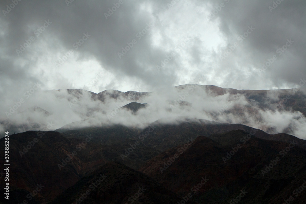 Dramatic cloudscape. Aerial view of the dark mountains silhouette, fog and clouds at sunrise. 