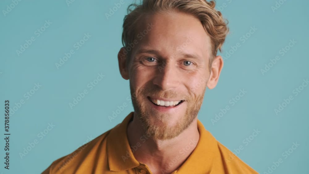 Young blond bearded smiling man amazedly looking in camera saying wow over colorful background Young blond bearded smiling man amazedly looking in camera saying wow over colorful background