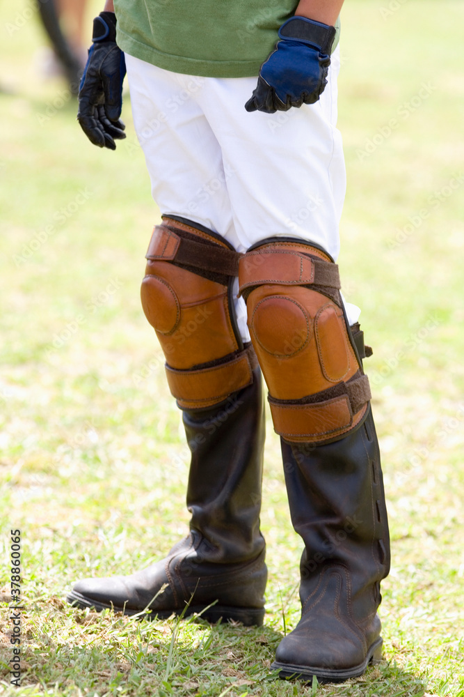 Fototapeta premium Low section view of a teenage boy wearing riding boots and kneepads 
