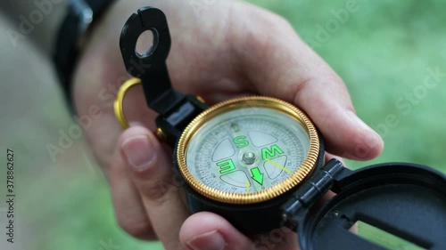 Man holds a compass in hand and looks for direction