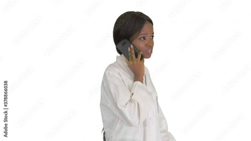 African american female doctor talking on the phone while walking on white background. African american female doctor talking on the phone while walking on white background.