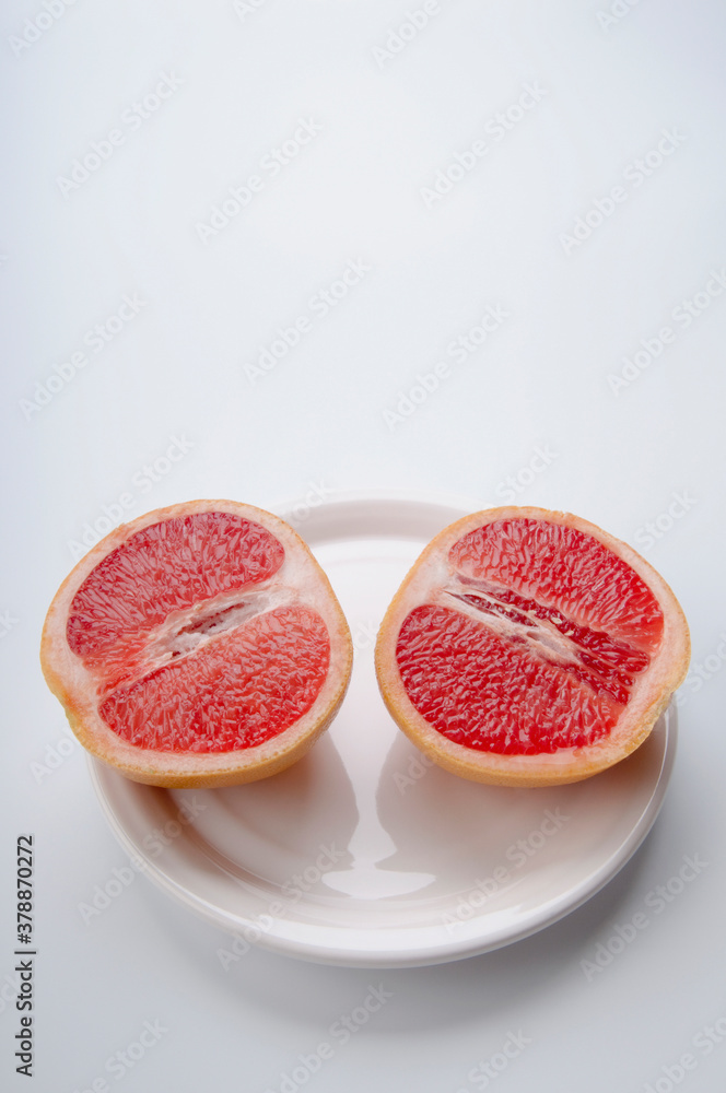 High angle view of two halves of grapefruit on a plate High angle view of two halves of grapefruit on a plate