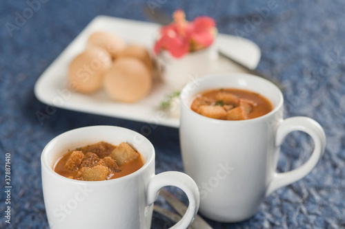 Two cups of tomato soup with bread cubes