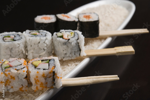 Close-up of various sushi with chopsticks on a plate