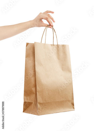 Female hand holding kraft paper shopping bag. Design mockup Isolated on white background.