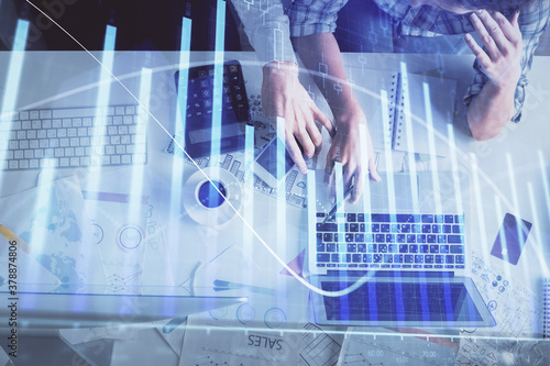 Double exposure of man and woman working together and financial graph hologram drawing. market analysis concept. Computer background. Top View.