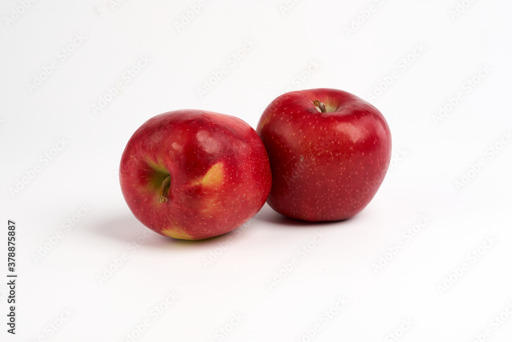 Two red shiny apples over white background