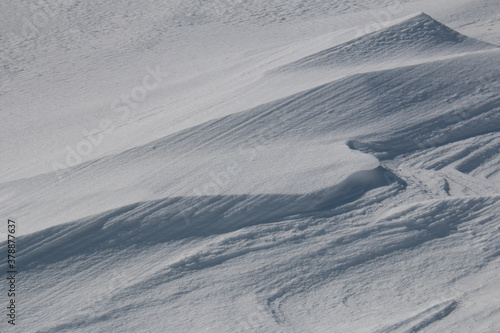 Natural patterns and ridges in windswept snow abstract background winter landscape © Alexandra Scotcher