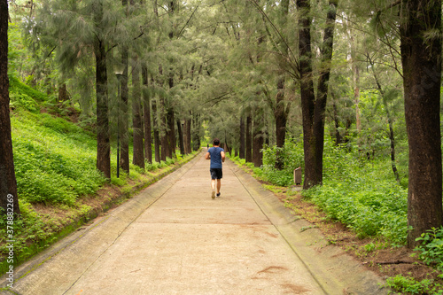 Un joven está corriendo en el bosque.