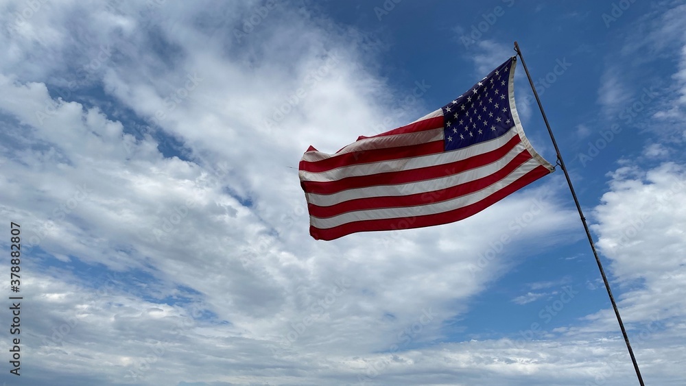 Waving American flag against blue sky and clouds. Waving American flag against blue sky and clouds.