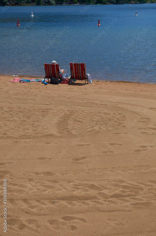 Beach chairs on lake beach at midday chilling out Beach chairs on lake beach at midday chilling out