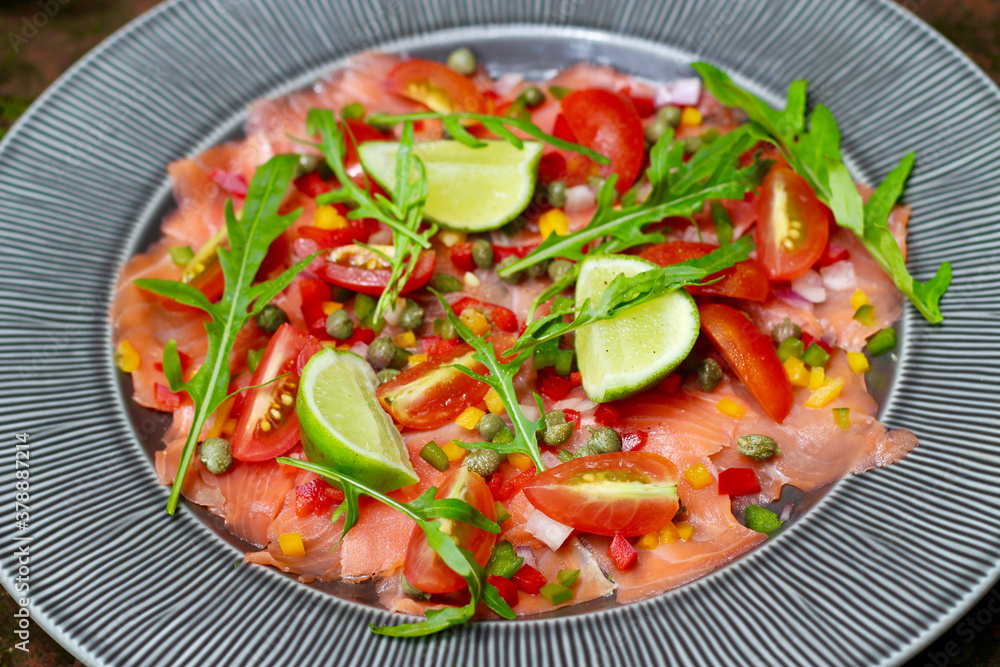 Smoked salmon carpaccio salad topped with capers, peppers, and rocket leaves. Smoked salmon carpaccio salad topped with capers, peppers, and rocket leaves.