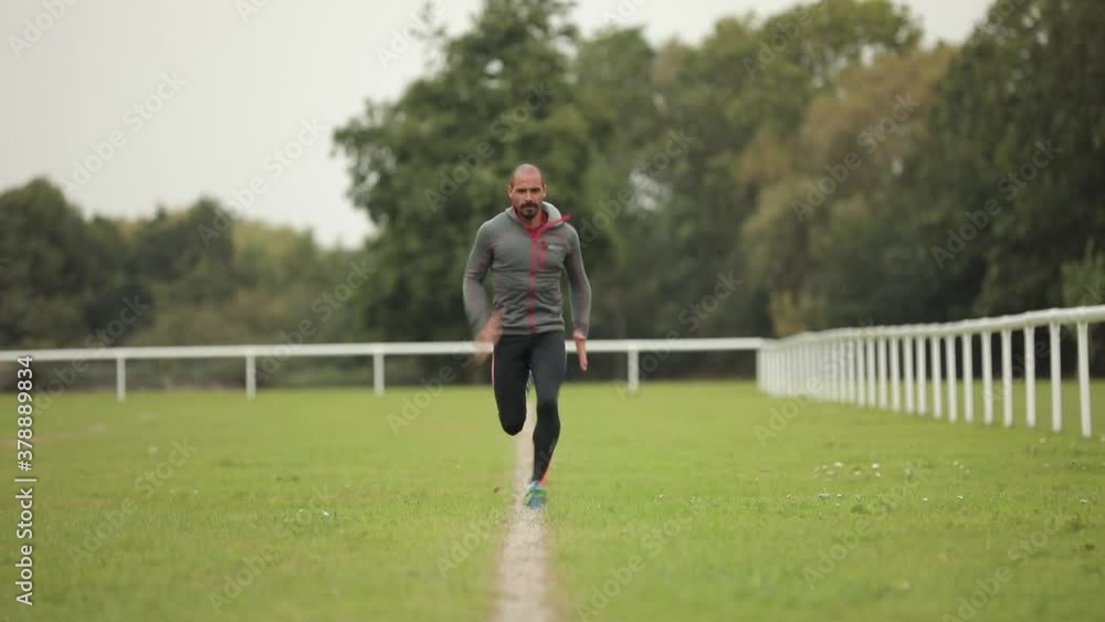 A male running towards camera on a playing field A male running towards camera on a playing field