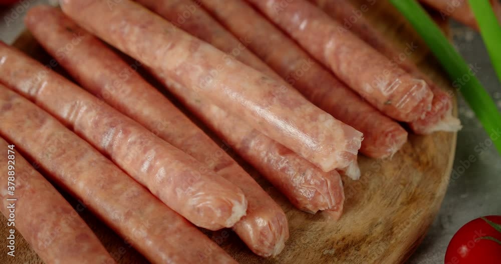 Homemade raw sausages on a wooden cutting board. Homemade raw sausages on a wooden cutting board.