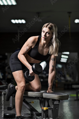 A young girl athlete trains with ten-kilogram dumbbells.