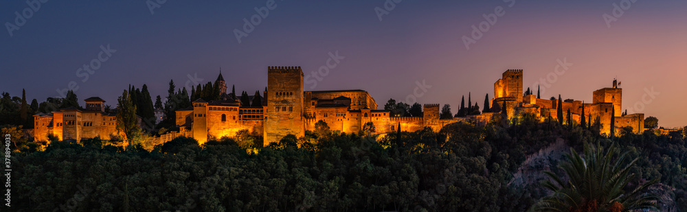 Granada, Spain. October 17th, 2020. View at sunset from below of the buildings and towers of the Alhambra illuminated by artificial lights.