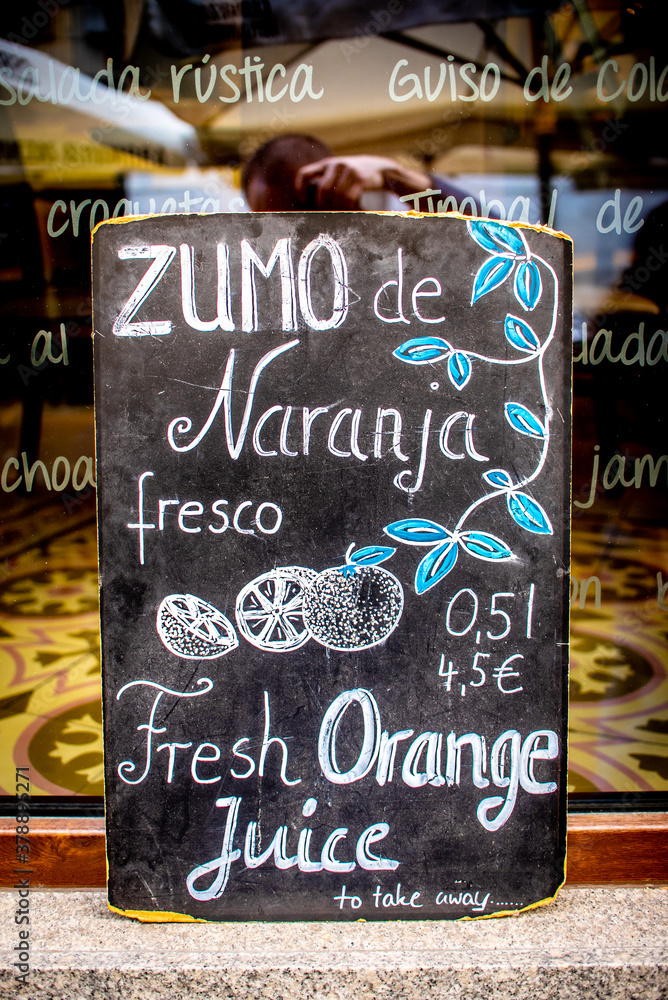 Seville, Spain. Signboard of a cafe bar for fresh orange juice to take away along the way in the center of the city, downtown Seville.