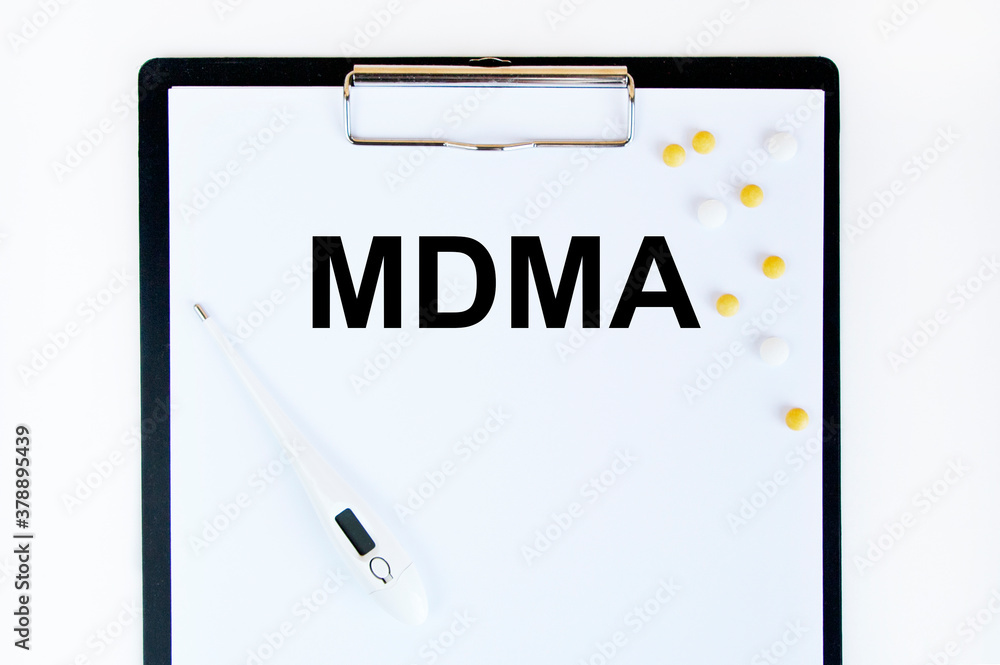 Text MDMA on a white background. Nearby are various medicines. Medical concept. Text MDMA on a white background. Nearby are various medicines. Medical concept.