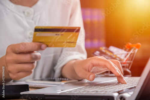 Girl holding credit card and typing on laptop, Online shopping concept. Close up.