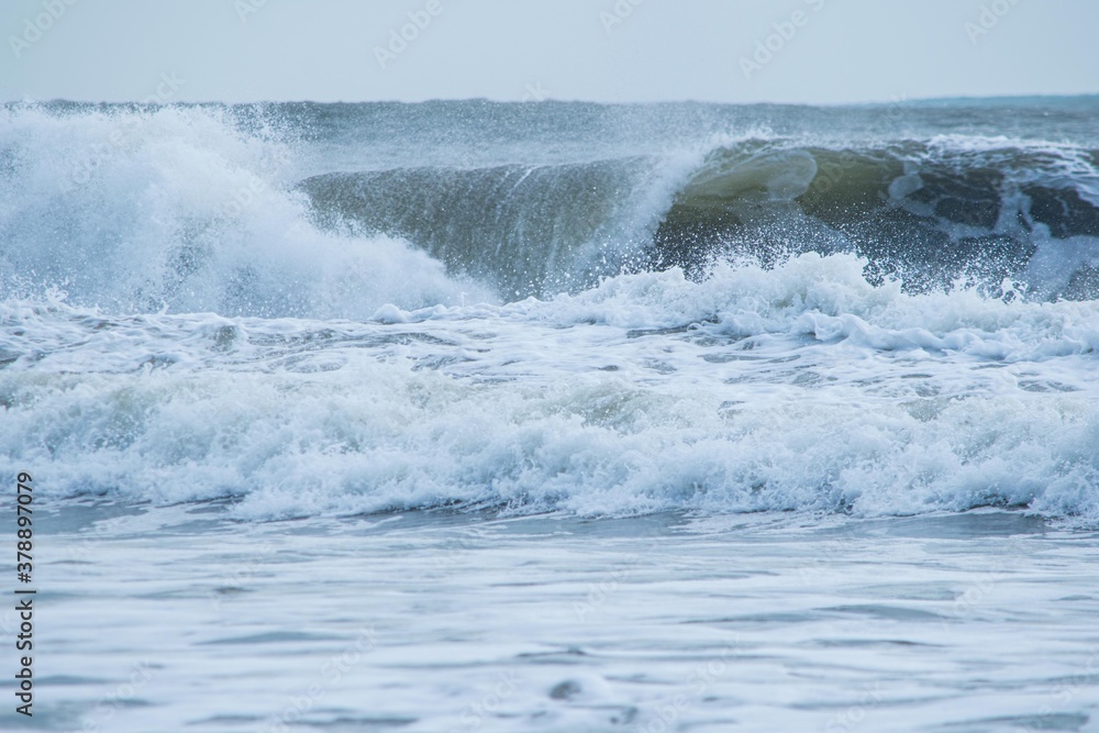 押し寄せては引き、海岸の砂を何度も洗い続ける海の荒波
