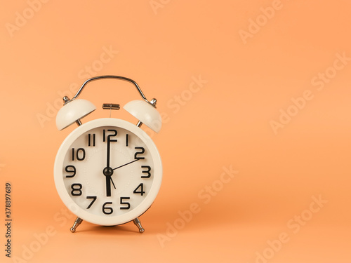 white vintage alarm clock show 6 O'clock on orange background. Morning routine , fresh start of the day.