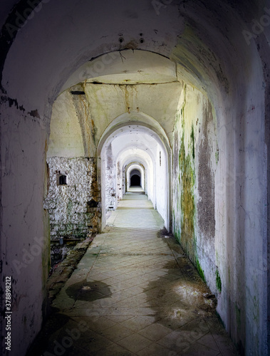 Corridor connecting the military fort in a state of neglect, walls dirty with mold and moss. Forte Leone, Cima Campo, Belluno, Italy © Emanuela