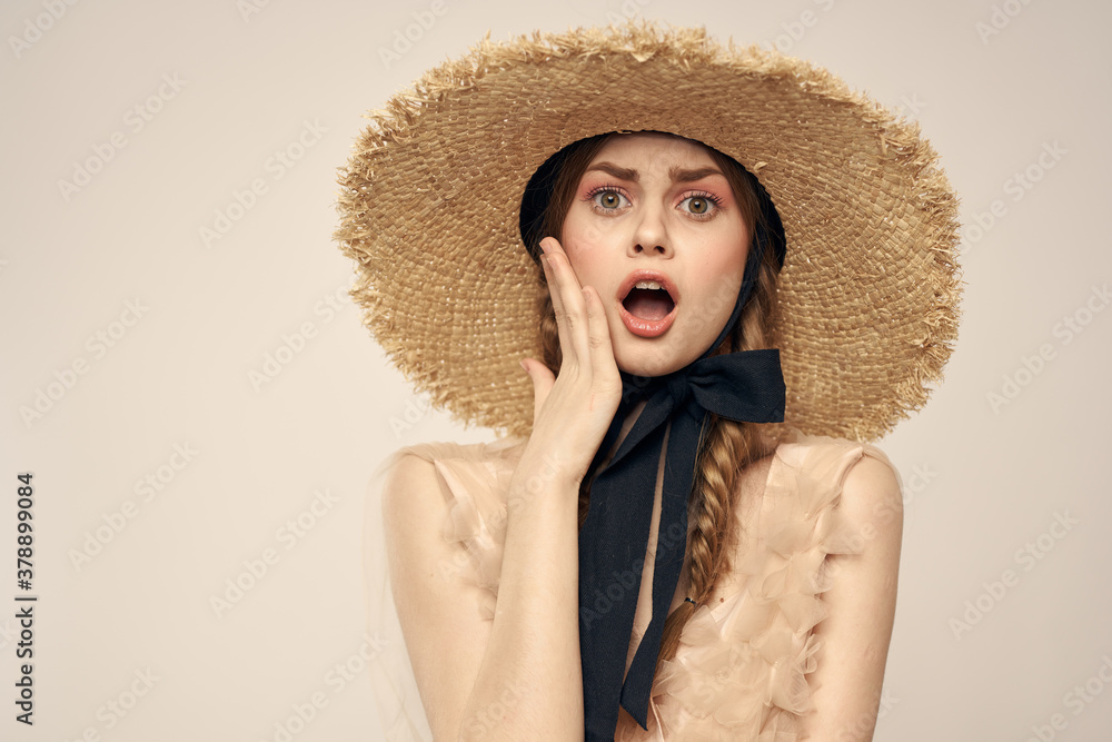 Romantic woman in a hat and dress on a light background gestures with her hands portrait fun emotions cropped view Romantic woman in a hat and dress on a light background gestures with her hands portrait fun emotions cropped view