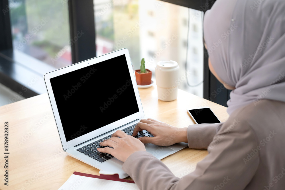 Confident Asia Muslim (Islam) businesswomen executive dressed in the religious veil, working in the modern office and looking on a laptop and planing a job. Work concept of diversity of culture.. Confident Asia Muslim (Islam) businesswomen executive dressed in the religious veil, working in the modern office and looking on a laptop and planing a job. Work concept of diversity of culture..