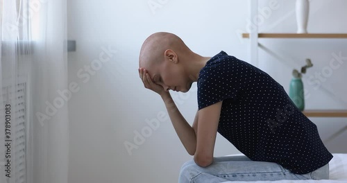 Bald after chemotherapy woman sit on bed bowing head feels hopeless and desperate due cancer incurable disease, malignant growth of tumour, loss of hope, unsuccessful ineffective treatment concept