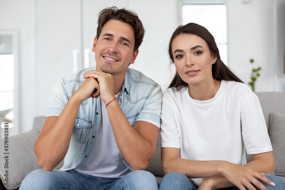 Portrait of couple sitting on couch in living room look at camera. Portrait of couple sitting on couch in living room look at camera.