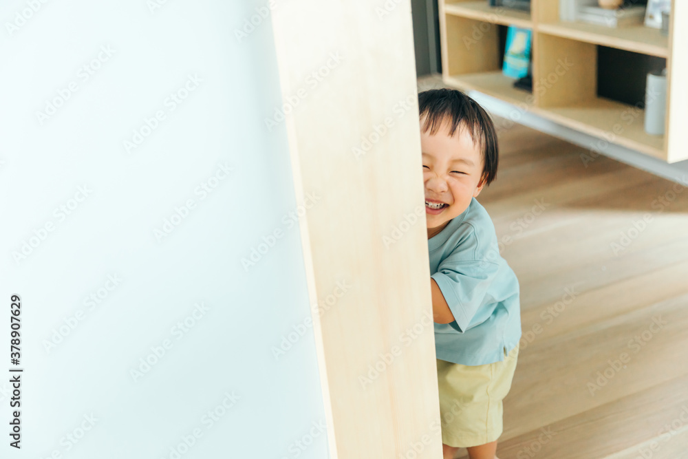 綺麗な新築の壁に男の子が笑顔で遊んでいる 綺麗な新築の壁に男の子が笑顔で遊んでいる