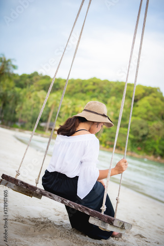 girl sitting on a quiet beach swing