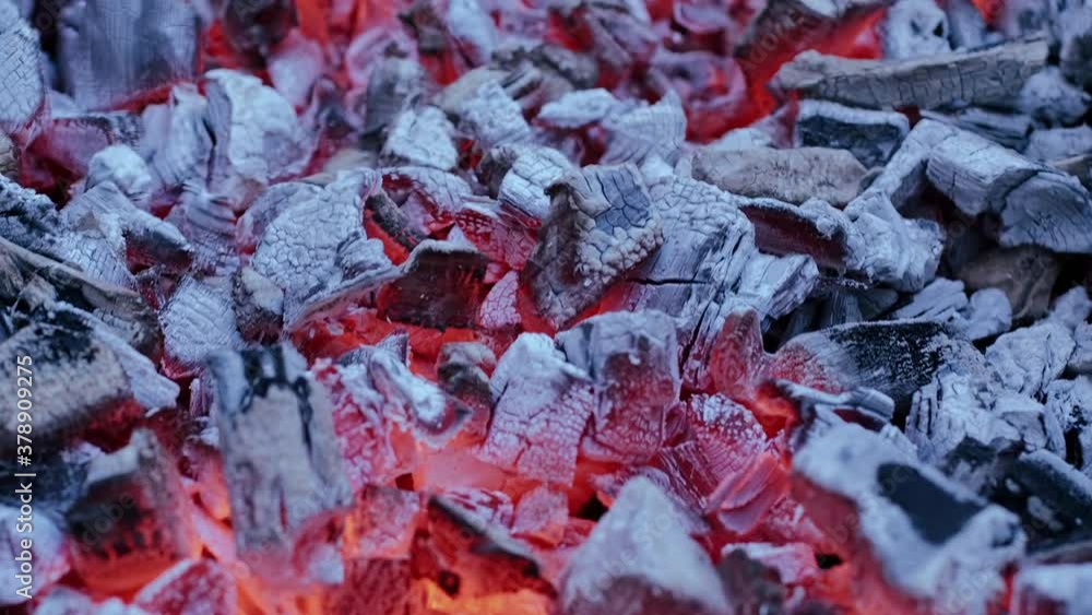 The video camera moves over the hot coals in the grill. The charcoal is smoldering and ready to cook grilled meat. The video camera moves over the hot coals in the grill. The charcoal is smoldering and ready to cook grilled meat.