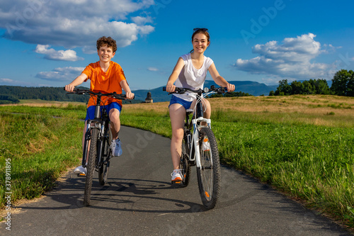 Healthy lifestyle - teenage girl and boy riding bicycles