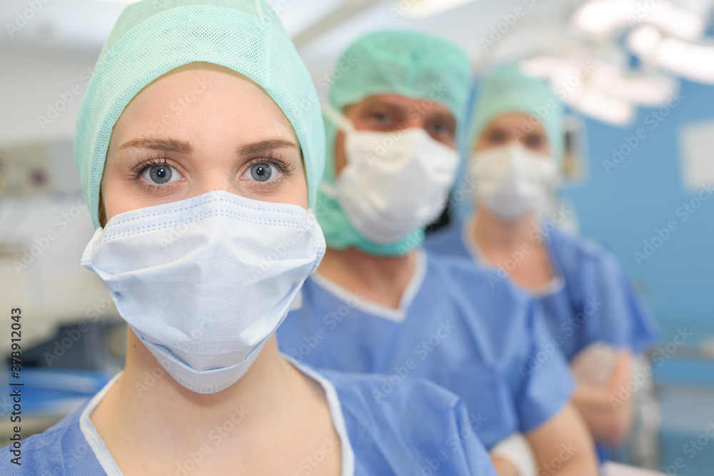 three surgeons at work operating in surgical theatre three surgeons at work operating in surgical theatre