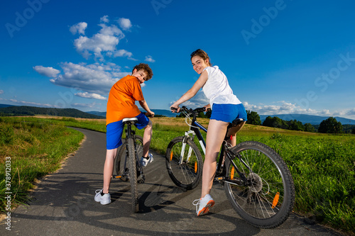 Fototapeta Naklejka Na Ścianę i Meble -  Healthy lifestyle - teenage girl and boy riding bicycles