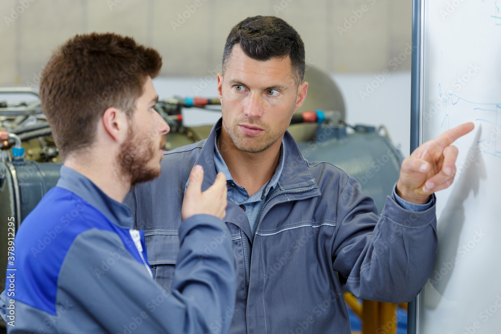 closeup of a worker pointing to a white board closeup of a worker pointing to a white board