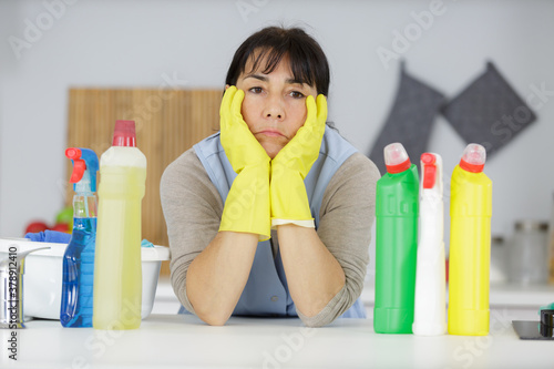 bored mature woman housewife with cleaning products