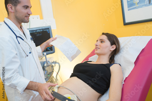 doctor using ultrasound and screening stomach of pregnant woman