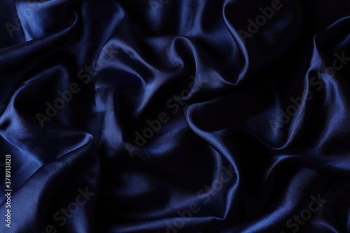 Blue glossy shiny material. Fabric texture. Drapery.