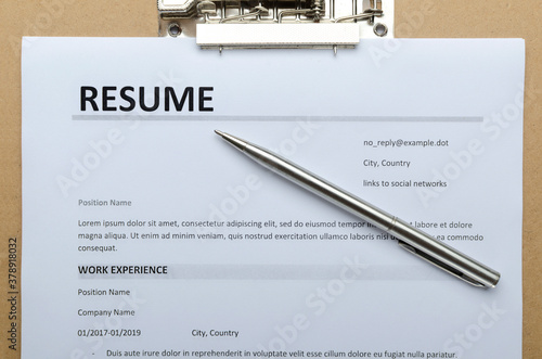Closeup and top view of resume form on the clipboard and silver pen