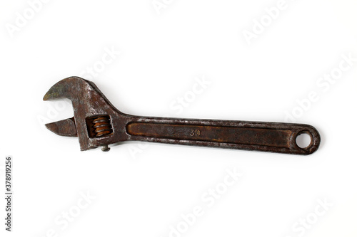 Old rusty adjustable spanner isolated on a white background.