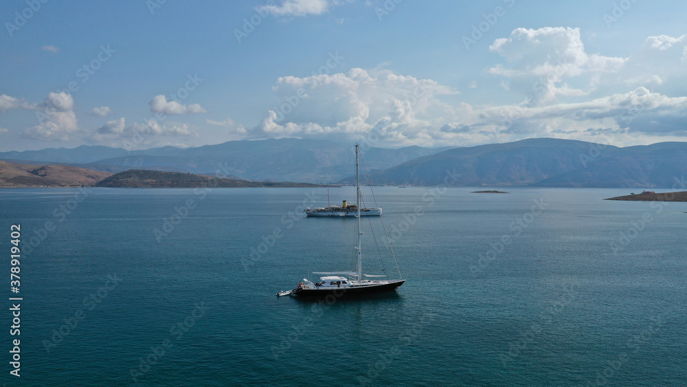 Aerial drone photo of classic wooden yacht anchored in Mediterranean bay with deep blue sea Aerial drone photo of classic wooden yacht anchored in Mediterranean bay with deep blue sea
