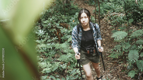 Woman tourist traveling adventure through the forest Successfully arrived at the destination until you reach the waterfall.wearing travel gear hat and camera.outdoor freedom lifestyle.