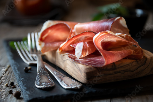 Italian prosciutto or jamon with rosemary, raw ham photo