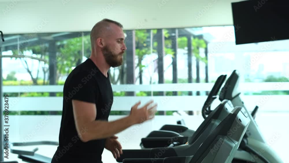 Handsome european man in gym on treadmill  