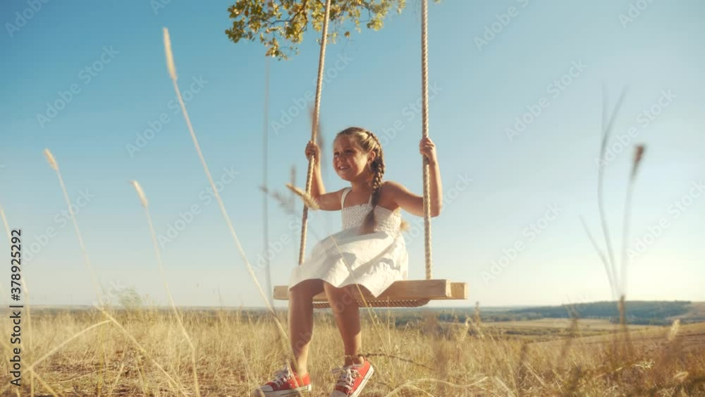 little girl kid swinging on wooden swing a tree in the park. happy family kid dream concept. little kid girl playing on wooden swing on tree dream concept in park. child a fun swing little girl kid swinging on wooden swing a tree in the park. happy family kid dream concept. little kid girl playing on wooden swing on tree dream concept in park. child a fun swing