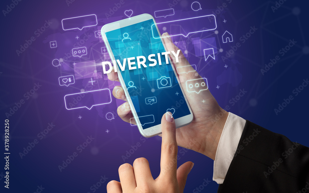 Female hand typing on smartphone with DIVERSITY inscription, social media concept Female hand typing on smartphone with DIVERSITY inscription, social media concept