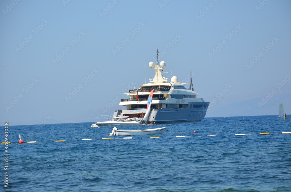 An ultra-luxury yacht anchored off the Aegean Sea.